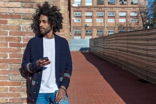 istock Afro man using mobile phone on street. 1364442456