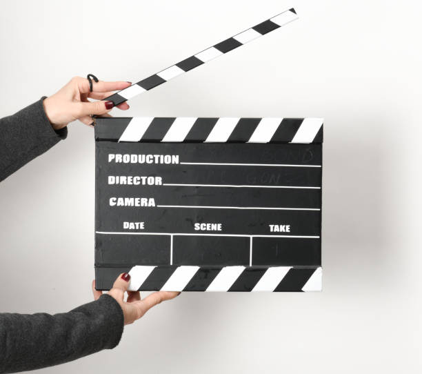 istock Woman with film clapper on white background 1364444384