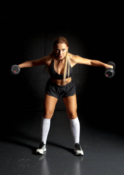 istock Muscular woman working out with dumbbells 1364445502