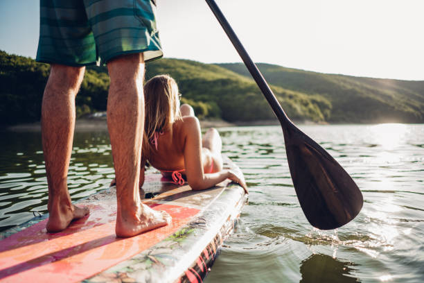 istock Cute young couple paddle boarding and selfie 1364445563