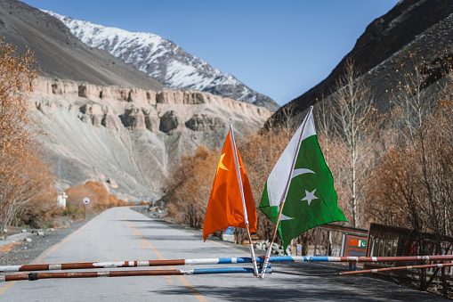 Chinese and Pakistani flag on  entrance to Karakoram Highway