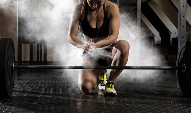 Woman workout with barbell at gym stock photo