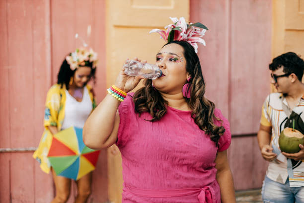 carnaval brasileño. persona bebiendo agua durante el bloque de carnaval en la calle - carnival drink people party fotografías e imágenes de stock