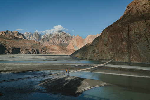 Young Caucasian woman walking on suspension bridge in Pakistan