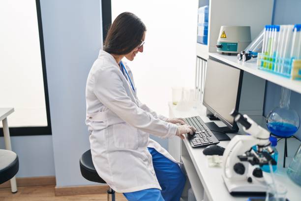 istock Young hispanic woman wearing scientist uniform working at laboratory 1364447199