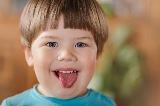 portrait of a little boy showing tongue