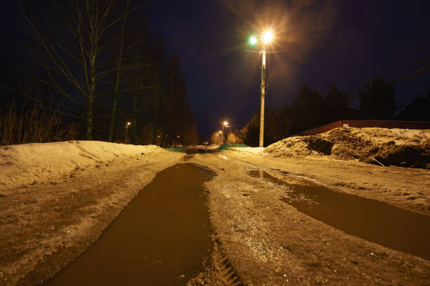 Long exposure photography. Russian winter countryside. Road and village are covered with frost. Spring coming, roads are wet and slippery. Concept of  the beauty in nature and lifestyle.