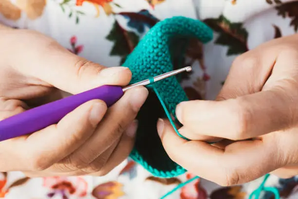 Women's hands doing crcohet with a close point of view. Homemade hobby artisan concept.