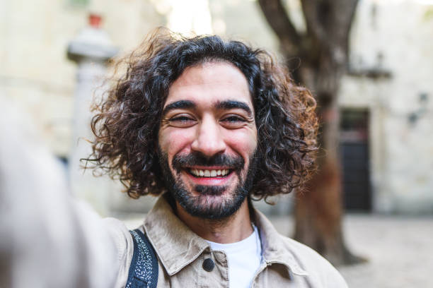 istock Cheerful man taking selfie on street 1364451265