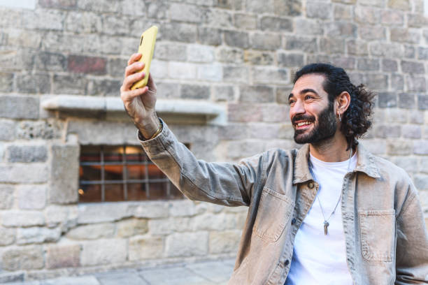 istock Positive man taking selfie on street 1364451281