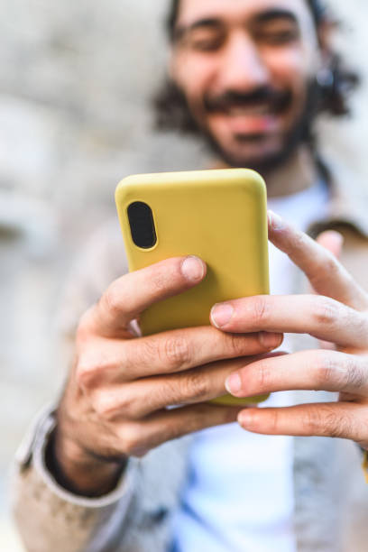 istock Cheerful man browsing smartphone on street 1364451283