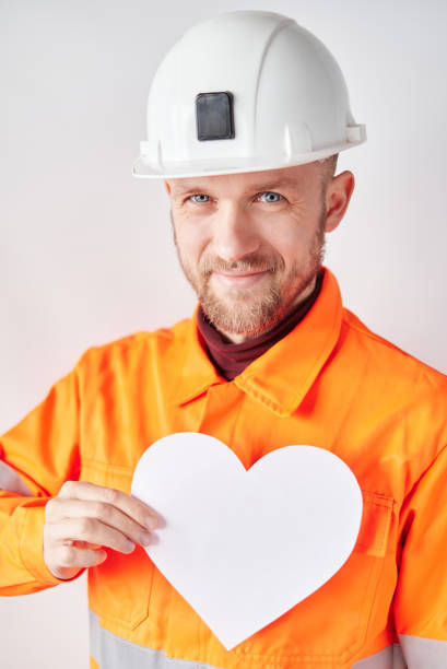 istock Construction worker in hard hat with white paper heart 1364453783