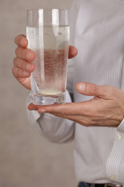 istock Man holding glass with Vitamin C effervescent tablet close up. 1364454758