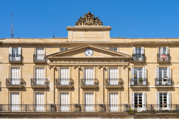Front facade with clock on top at new square in Bilbao built in 1851. Neoclassical architectue style concept. Translation: Basque language academy