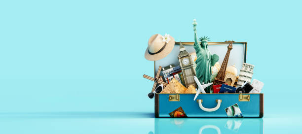 istock Blue suitcase full of landmarks and travel accessory on blue background 1364457396