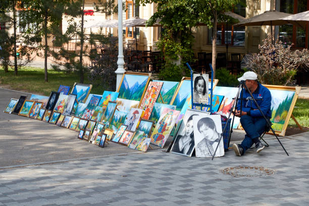 street artist selling his paintings on the sidewalk in Almaty, Kazakhstan in June 20, 2021