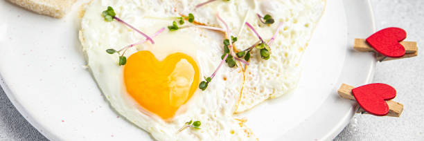 istock valentines day fried egg breakfast on the table scrambled eggs heart shape holiday decoration love date copy space food background 1364458646