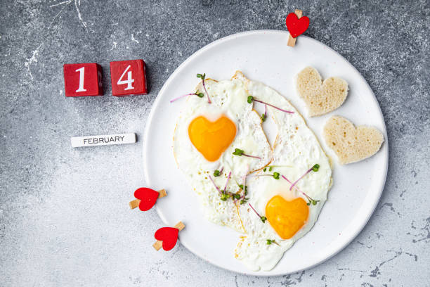 istock valentines day fried egg breakfast on the table scrambled eggs heart shape holiday decoration love date copy space food background 1364458658