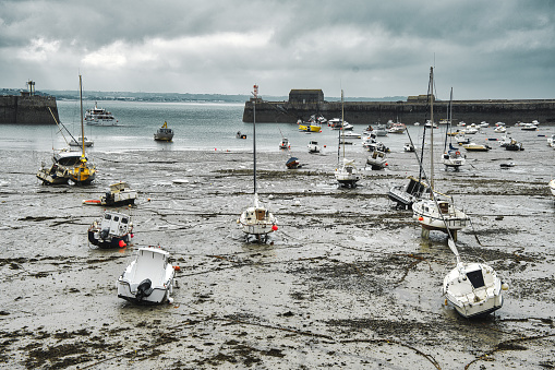 Normandy, France, August 27, 2019: Grounded boats waiting for the next high tide at the harbor of Grandville, Normandy in France.
