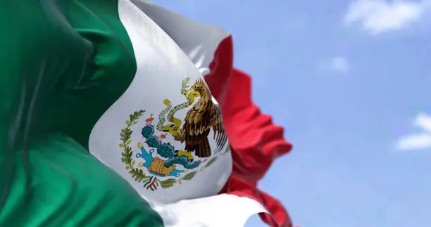 Detailed close up of the national flag of Mexico waving in the wind on a clear day. Democracy and politics. Latin american country. Selective focus.