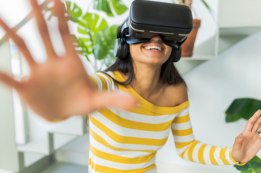 woman wearing virtual reality glasses at home