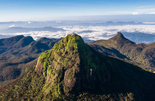 Adam's Peak is a 2243 m tall conical mountain located in central Sri Lanka - Sacred Mountain for four religions with a temple on the top. Aerial flying drone shot. stock photo