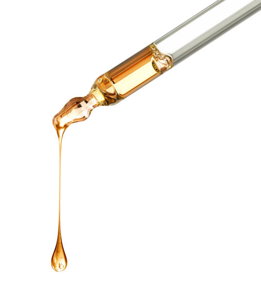 istock Stretched oily drop falls from a pipette close-up isolated on a white background 1364467230