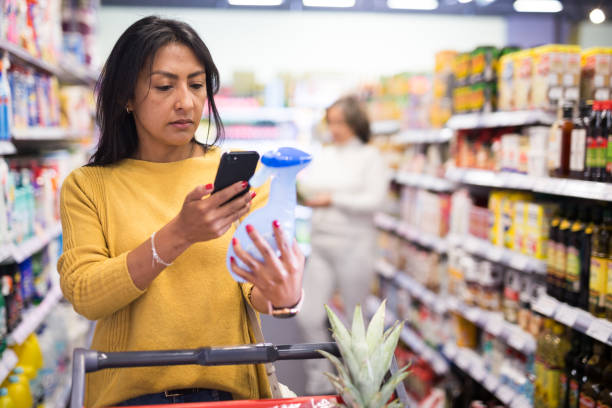 istock Hispanic woman scanning barcode on detergent bottle in supermarket 1364468978