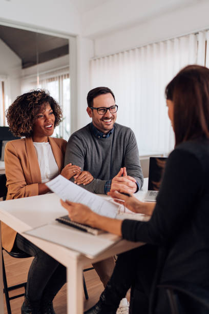 Couple consulting with a female financial manager at the bank stock photo