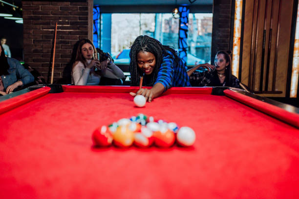 istock Woman with friends playing billiards 1364470218