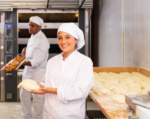 istock Woman baker demonstrates ready dough for baking in oven 1364471633