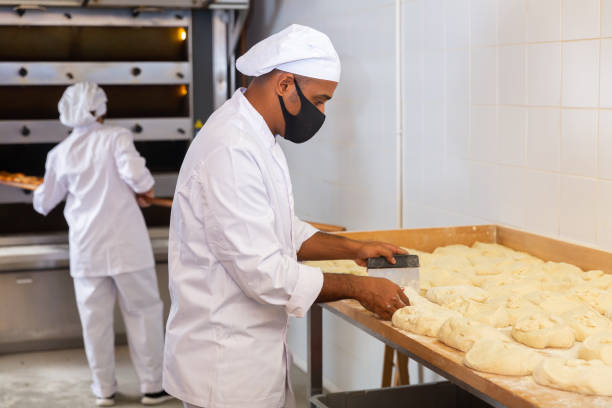 istock Skilled bakery worker portioning dough and weighing pieces 1364471634