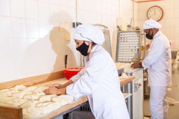 istock Skilled woman baker forming dough for baking bread 1364471690