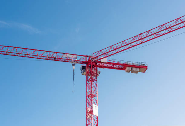 istock two red tower cranes against blue sky 1364473292
