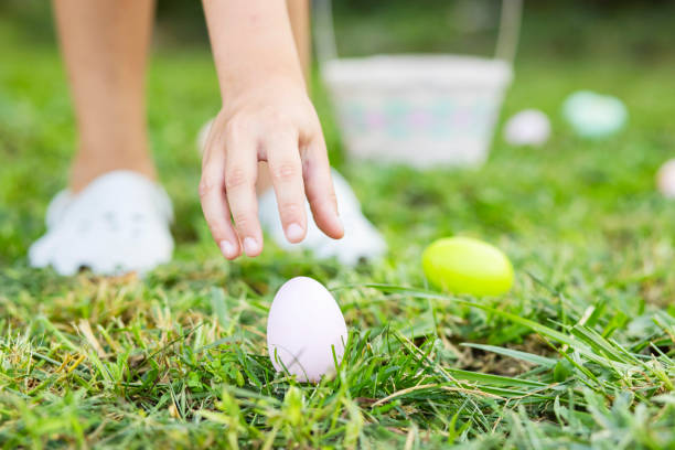 little boy hunting for egg in spring garden on easter day. traditional easter festival outdoors. easter egg hunt concept - color image jesus christ child people imagens e fotografias de stock