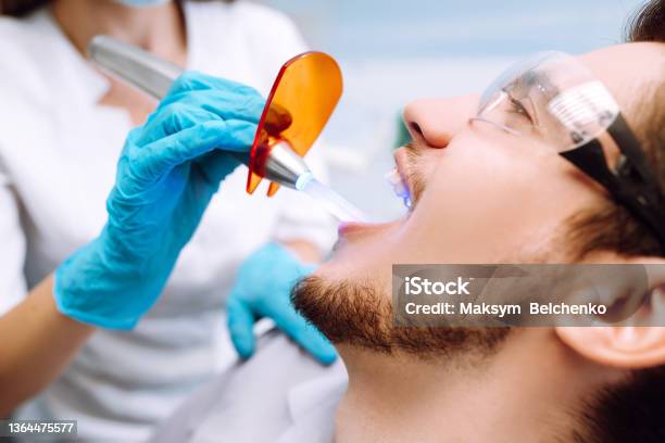 Junger Mann Am Zahnarztstuhl Während Eines Zahnärztlichen Eingriffs Überblick Über Die Kariesprävention Stockfoto und mehr Bilder von 20-24 Jahre