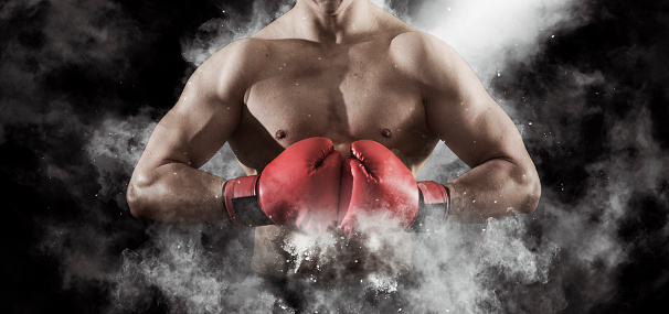 Man boxer in red gloves on black background. Sports banner. Horizontal copy space background