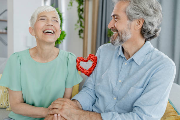 istock Happy senior laughing and holding hands 1364475877