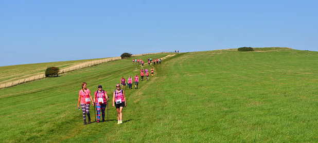 Alciston, East Sussex, England - September 01, 2018 : Race For Life Lady walkers in pink on the South Downs.