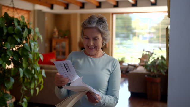 Happy senior woman at home reading a letter she got in the mail very excited