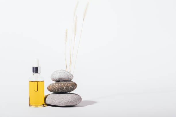 istock Cosmetic oil next to stack of stones and bunch dry spikelets 1364482548