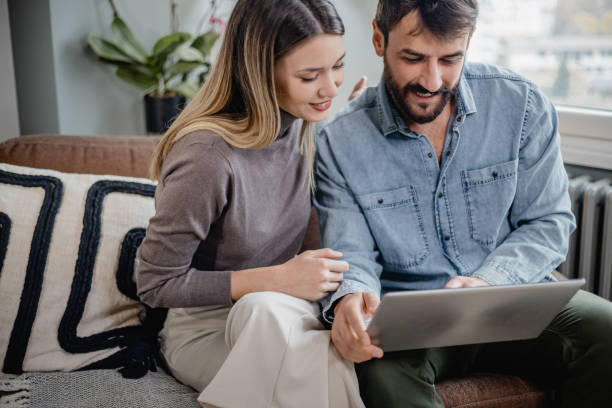 istock Young couple using laptop at home 1364484614