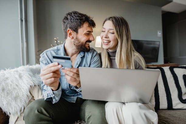 istock Young couple using laptop and doing activities E-commerce at home 1364484769