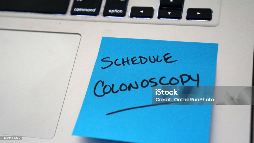 Reminder to Schedule Colonoscopy Sticky note reminder to schedule colonoscopy to screen for colorectal cancer. Colonoscopy Stock Photo