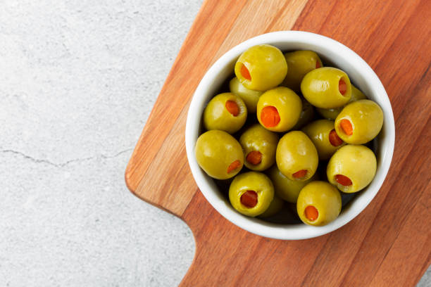 nadziewane zielone oliwki w misce. - green olive zdjęcia i obrazy z banku zdjęć