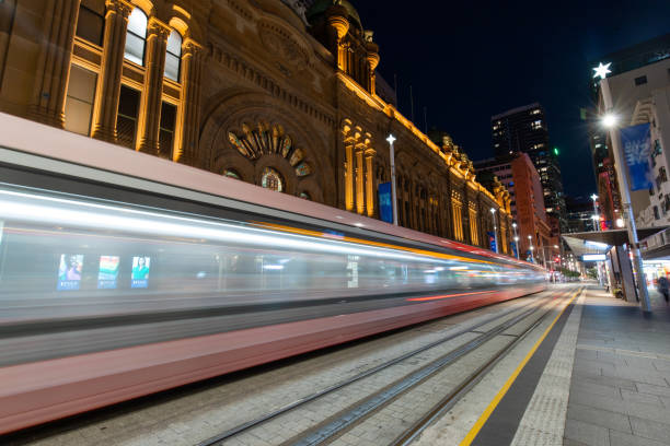 Tram passing QVB Sydney, Australia - January 2, 2022: Tram passing through QVB at night. st george street stock pictures, royalty-free photos & images