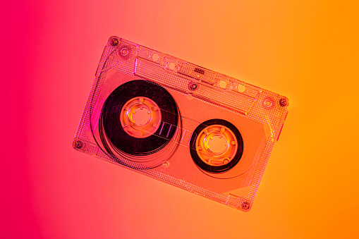 Plastic transparent cassette tape - pink and orange background, pop art style