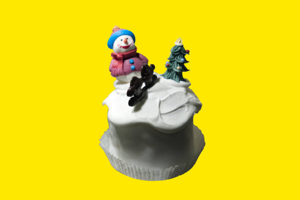 a cupcake decorated with a winter theme isolated on a yellow background