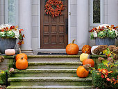 Front door with fall harvest decorations with pumpkins for Halloween