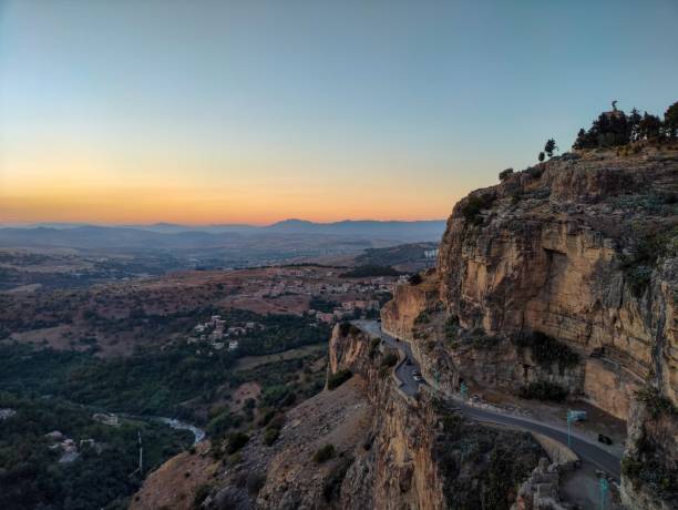 アルジェリアのコンスタンティンの日��没時に道路が交差するロッキーヒル - travel destinations hill landscape house ストックフォトと画像